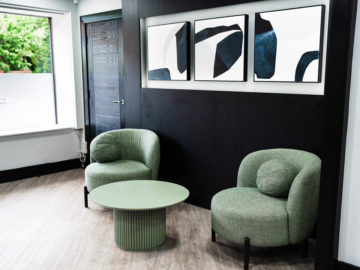 Waiting lounge at Bank Dental with green armchairs